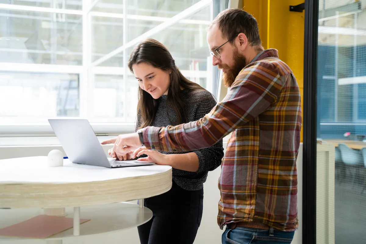 Two people look at a laptop during the innovation and development of a new product