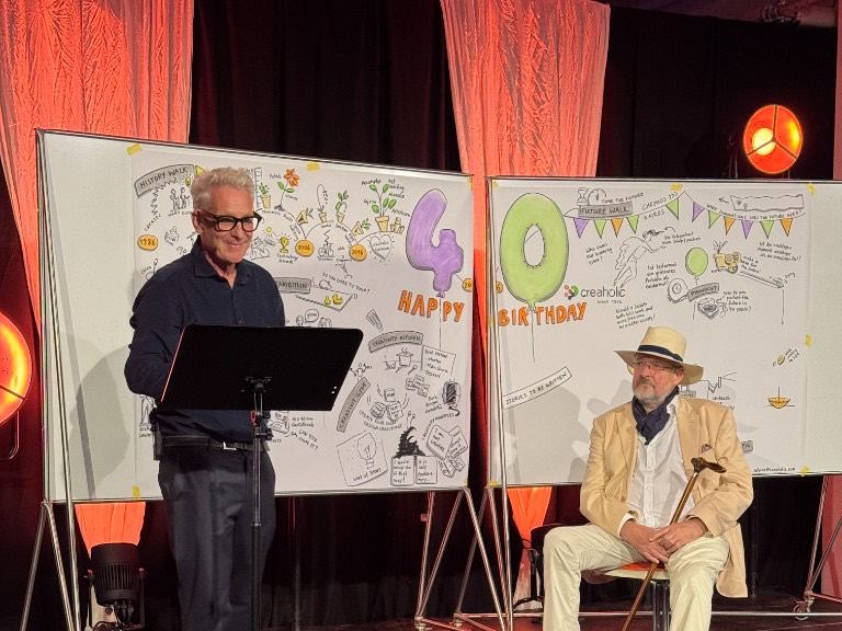A stage with boards reading Happy 40th Birthday, Creaholic.