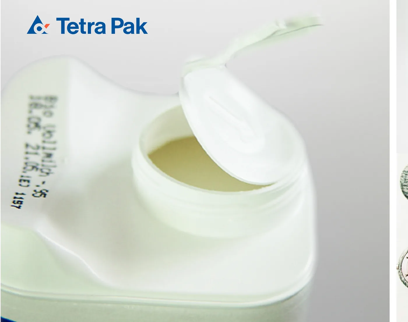 A Tetra Pak container with an over-moulded paperboard body and a hinged lid
