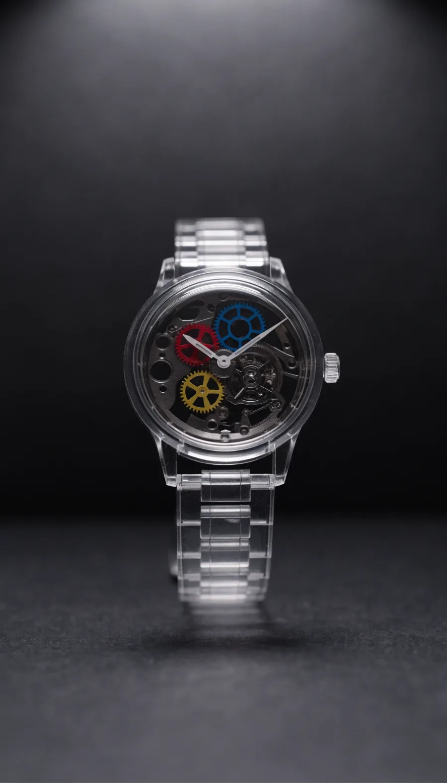 A transparent skeleton watch, its coloured movement visible through the case